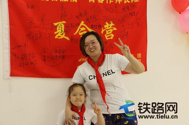 1501841983995196.jpg 秦憲瑩與李婧伊母女在夏令營(yíng)旗前合影.jpg